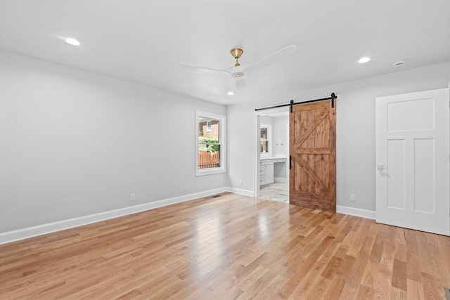 810 Cooper Dr, Lexington, KY 40502 - unfurnished bedroom featuring a barn door, light wood-style flooring, baseboards, recessed lighting, and ensuite bathroom
