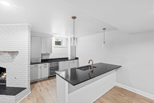 810 Cooper Dr, Lexington, KY 40502 - kitchen with beverage cooler, a peninsula, a sink, light wood finished floors, and baseboards