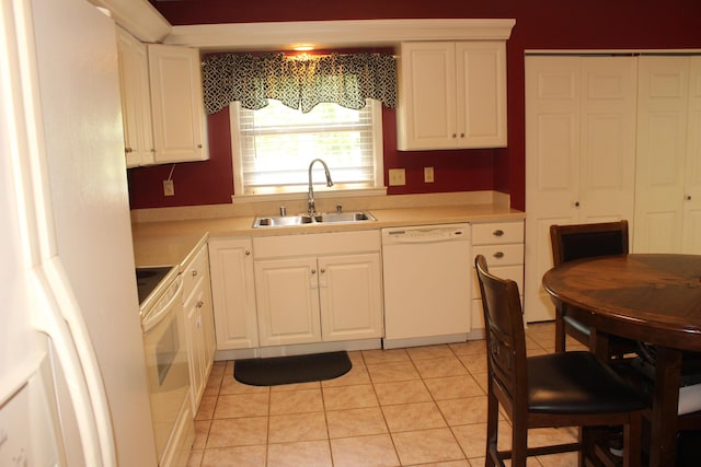kitchen with white appliances, a sink, light countertops, and white cabinets