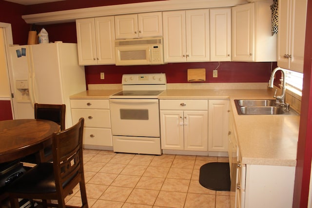 kitchen with white appliances, a sink, white cabinetry, and light countertops