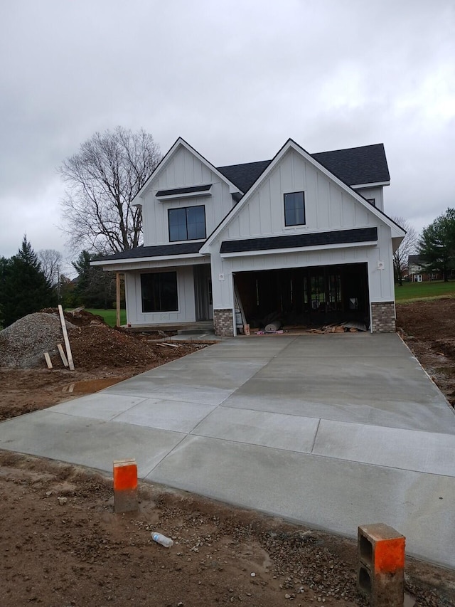 modern inspired farmhouse featuring board and batten siding, driveway, and roof with shingles