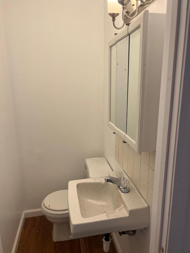 104 Arvin Dr, Lancaster, KY 40444 - half bathroom with backsplash, wood finished floors, a sink, toilet, and baseboards
