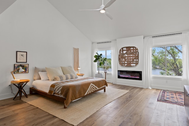 543 Laketower Dr Unit 140, Lexington, KY 40502 - bedroom featuring light wood-type flooring, high vaulted ceiling, a glass covered fireplace, baseboards, and ceiling fan