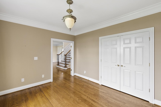 4301 Ravens Crest Ln, Lexington, KY 40515 - unfurnished dining area with baseboards, ornamental molding, stairs, and wood finished floors