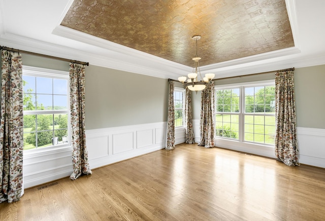 4301 Ravens Crest Ln, Lexington, KY 40515 - unfurnished room with a tray ceiling, a chandelier, crown molding, a wainscoted wall, and wood finished floors