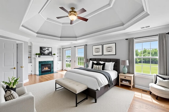 4301 Ravens Crest Ln, Lexington, KY 40515 - bedroom with a tray ceiling, access to outside, light wood-type flooring, a high end fireplace, and ceiling fan