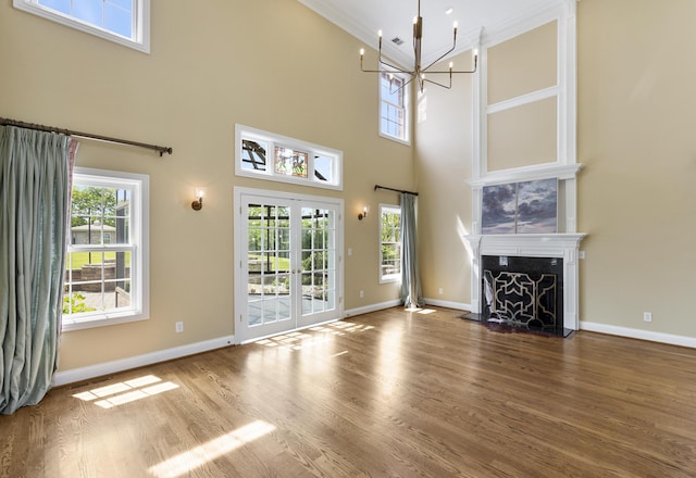 4301 Ravens Crest Ln, Lexington, KY 40515 - unfurnished living room featuring a chandelier, ornamental molding, wood finished floors, a towering ceiling, and baseboards
