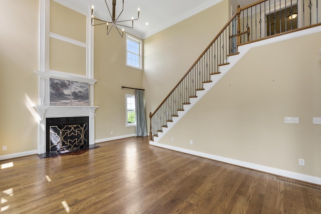 4301 Ravens Crest Ln, Lexington, KY 40515 - unfurnished living room with healthy amount of natural light, wood finished floors, a chandelier, crown molding, and a high ceiling