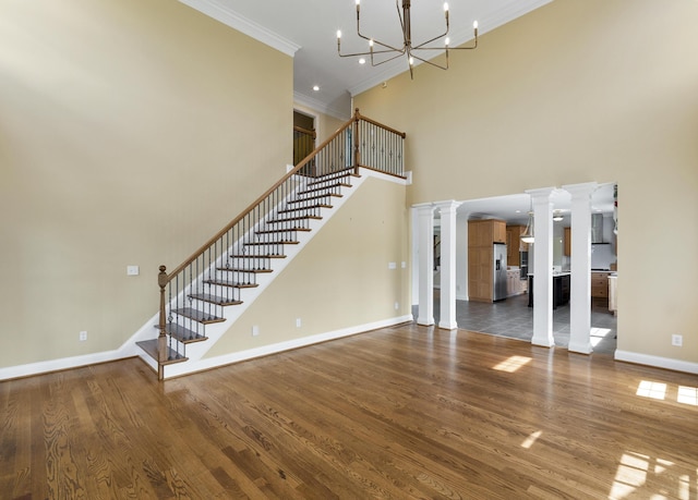 4301 Ravens Crest Ln, Lexington, KY 40515 - unfurnished living room featuring ornamental molding, decorative columns, baseboards, stairs, and a chandelier