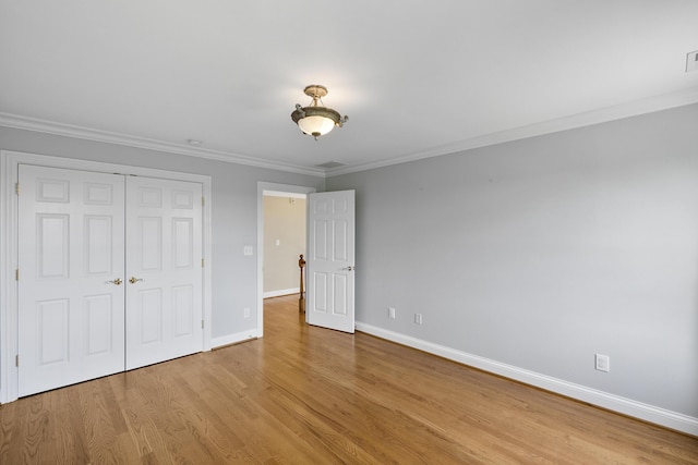4301 Ravens Crest Ln, Lexington, KY 40515 - unfurnished bedroom featuring baseboards, ornamental molding, light wood-style floors, and a closet