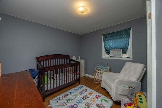 1667 Strader Dr, Lexington, KY 40505 - bedroom featuring wood finished floors, cooling unit, baseboards, and a nursery area