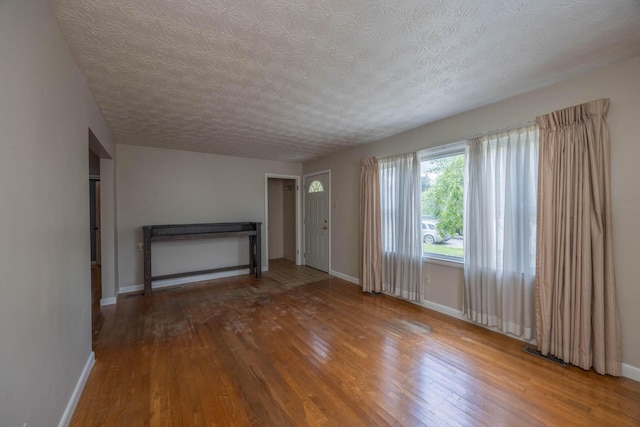 1667 Strader Dr, Lexington, KY 40505 - unfurnished living room with wood-type flooring, baseboards, and a textured ceiling