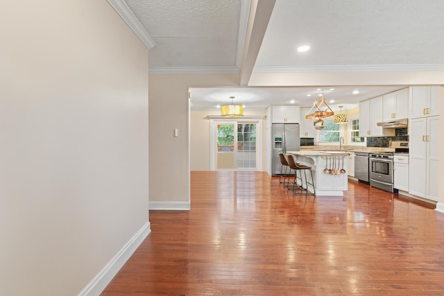 3514 Ramsgate Ct, Lexington, KY 40503 - kitchen featuring stainless steel appliances, under cabinet range hood, a breakfast bar, hardwood / wood-style flooring, and a kitchen island