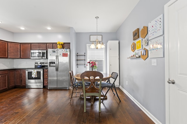 2768 Red Clover Ln, Lexington, KY 40511 - kitchen featuring appliances with stainless steel finishes, a chandelier, dark wood-type flooring, pendant lighting, and backsplash