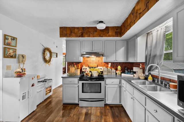 kitchen with stainless steel range with electric stovetop, a sink, decorative backsplash, and healthy amount of natural light