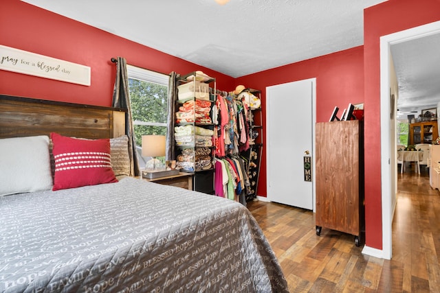 bedroom with wood finished floors, a textured ceiling, and a closet
