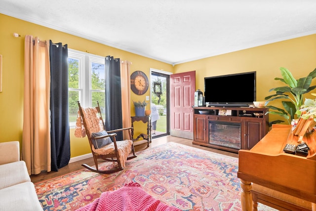 living room with healthy amount of natural light, light wood-style flooring, ornamental molding, and baseboards