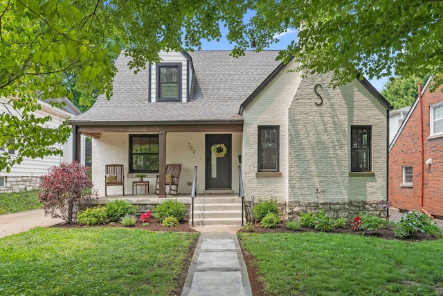 252 Cochran Rd, Lexington, KY 40502 - english style home featuring covered porch, a front yard, brick siding, and a shingled roof