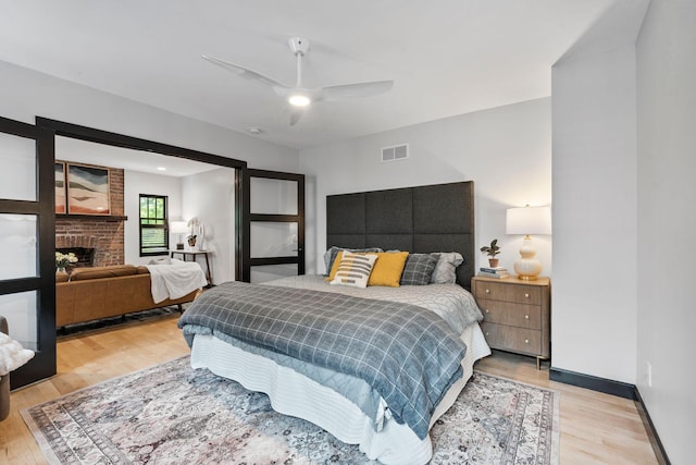 252 Cochran Rd, Lexington, KY 40502 - bedroom featuring light wood-style floors, a brick fireplace, baseboards, and ceiling fan