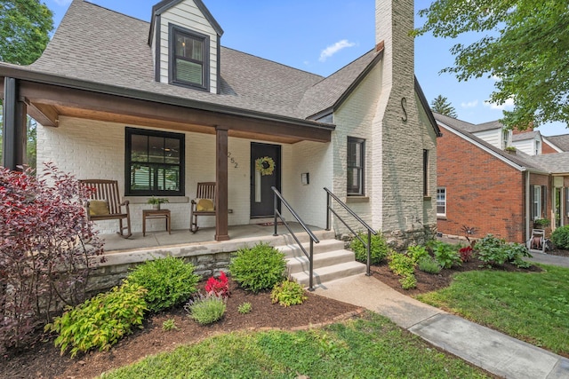 252 Cochran Rd, Lexington, KY 40502 - view of front of house with a porch, brick siding, a shingled roof, and a chimney