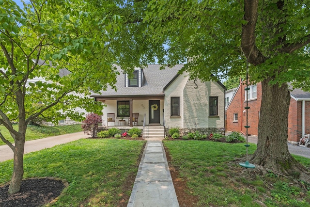 252 Cochran Rd, Lexington, KY 40502 - view of front of house featuring covered porch, a front lawn, brick siding, and roof with shingles
