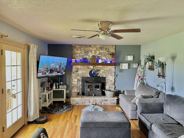 3125 Old Bull Rd, Eubank, KY 42567 - living area featuring a ceiling fan, a textured ceiling, wood finished floors, and a wood stove