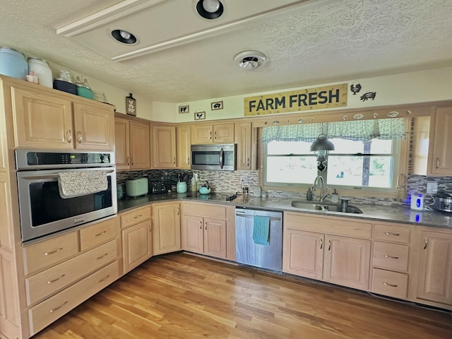 3125 Old Bull Rd, Eubank, KY 42567 - kitchen with appliances with stainless steel finishes, a sink, light brown cabinets, a textured ceiling, and decorative backsplash