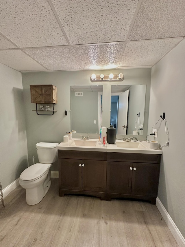 3125 Old Bull Rd, Eubank, KY 42567 - bathroom with wood finished floors, double vanity, a drop ceiling, toilet, and baseboards