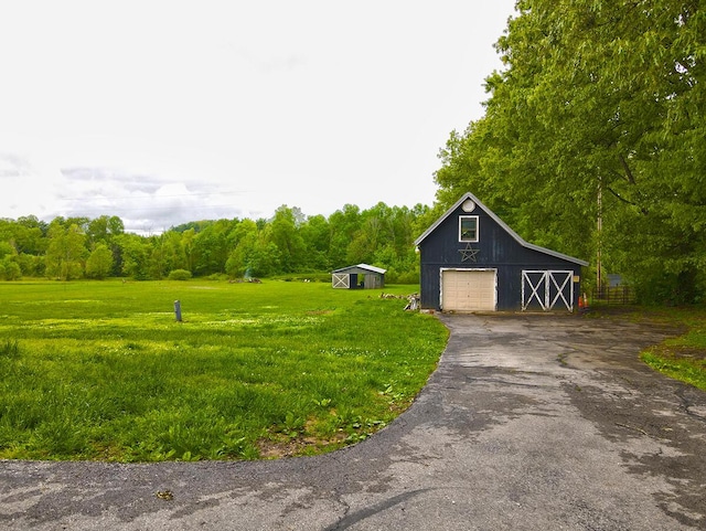 3125 Old Bull Rd, Eubank, KY 42567 - view of green lawn featuring an outdoor structure, a garage, asphalt driveway, and a barn