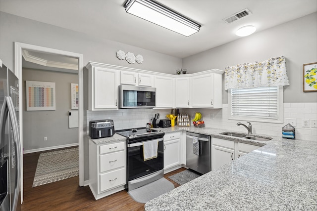 kitchen with appliances with stainless steel finishes, a sink, backsplash, and light stone counters