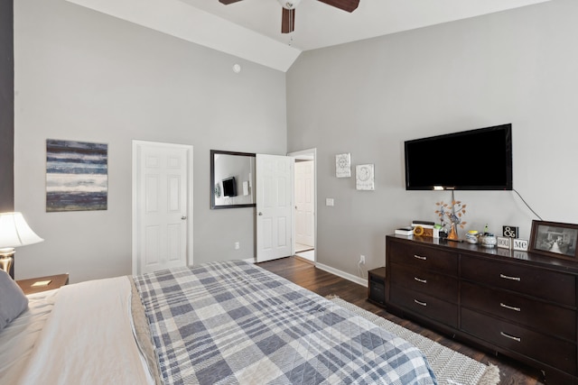 bedroom featuring dark wood-type flooring, high vaulted ceiling, baseboards, and ceiling fan