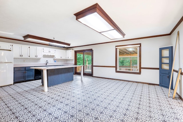 10708 Battlefield Memorial Hwy, Berea, KY 40403 - kitchen featuring freestanding refrigerator, white cabinetry, light countertops, a sink, and crown molding
