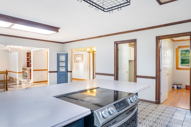 10708 Battlefield Memorial Hwy, Berea, KY 40403 - kitchen with stainless steel range with electric cooktop, light wood-type flooring, light countertops, ornamental molding, and baseboards