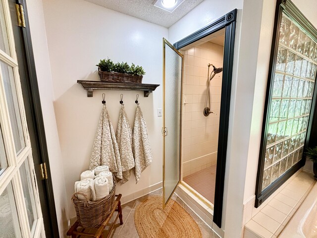 1610 Steele Branch Rd, West Liberty, KY 41472 - bathroom with a stall shower, a textured ceiling, tile patterned flooring, and baseboards