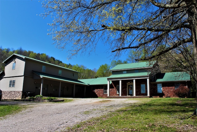 1610 Steele Branch Rd, West Liberty, KY 41472 - view of front of property with dirt driveway, covered porch, metal roof, a front yard, and brick siding