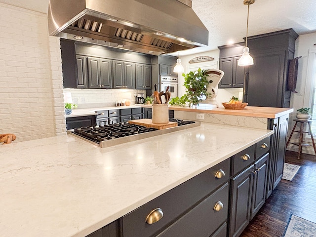 1610 Steele Branch Rd, West Liberty, KY 41472 - kitchen featuring wall chimney range hood, oven, stainless steel gas stovetop, dark wood-style flooring, and hanging light fixtures