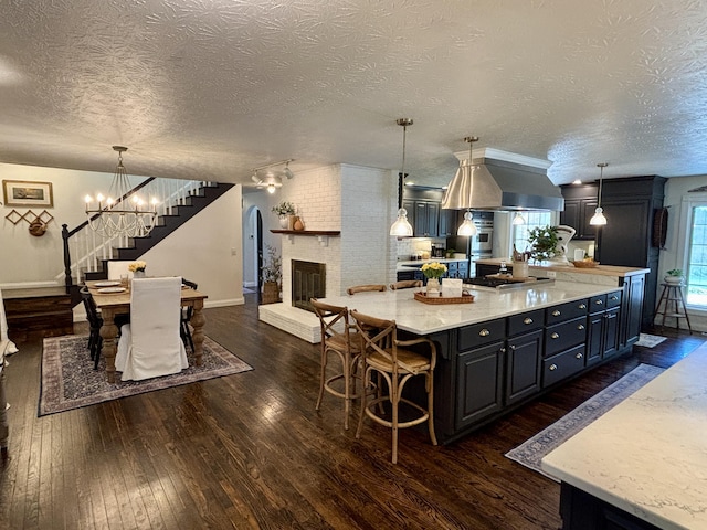 1610 Steele Branch Rd, West Liberty, KY 41472 - kitchen with dark wood finished floors, baseboards, open floor plan, a textured ceiling, and a kitchen bar