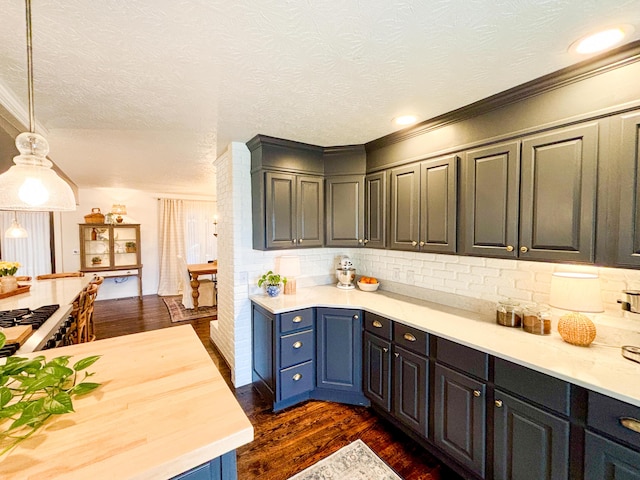 1610 Steele Branch Rd, West Liberty, KY 41472 - kitchen featuring dark wood-type flooring, backsplash, a textured ceiling, pendant lighting, and crown molding