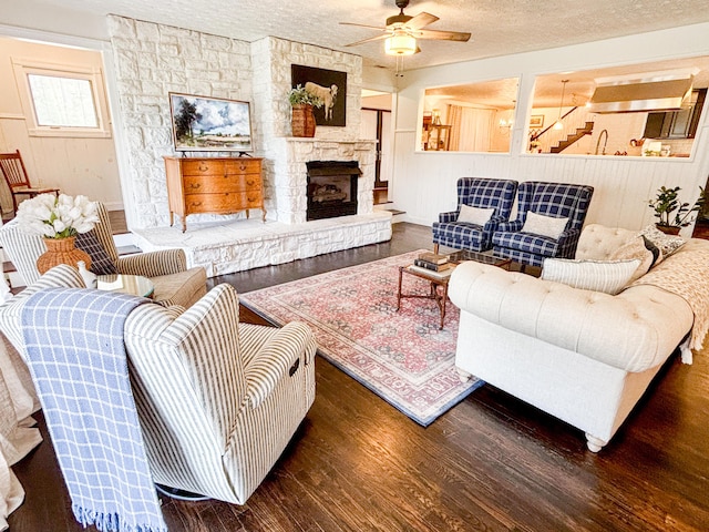 1610 Steele Branch Rd, West Liberty, KY 41472 - living area with wood finished floors, a ceiling fan, a textured ceiling, and a stone fireplace