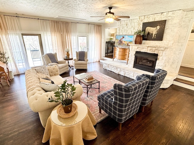 1610 Steele Branch Rd, West Liberty, KY 41472 - living area with wood finished floors, a ceiling fan, a stone fireplace, and a textured ceiling