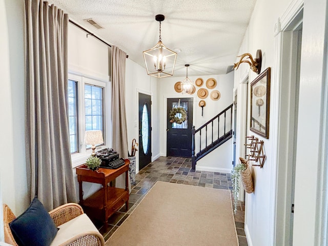 1610 Steele Branch Rd, West Liberty, KY 41472 - entrance foyer featuring a chandelier, stone tile floors, a textured ceiling, stairs, and baseboards