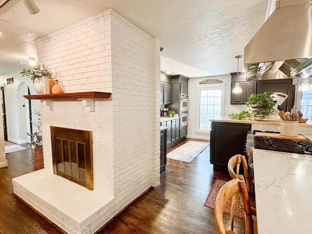 1610 Steele Branch Rd, West Liberty, KY 41472 - living room with a textured ceiling, a brick fireplace, dark wood finished floors, and plenty of natural light