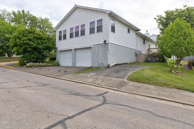 202 Strother St, Mt Sterling, KY 40353 - view of property exterior featuring asphalt driveway, a garage, central AC, and a yard