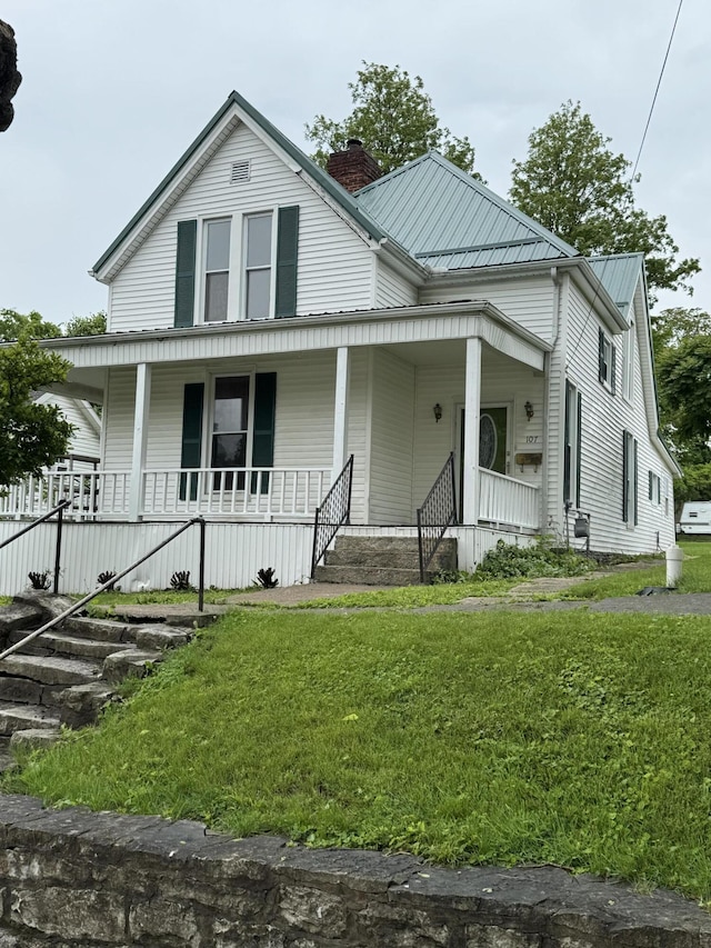 107 E N St, Carlisle, KY 40311 - view of front of home featuring a porch, a chimney, a front yard, and a metal roof