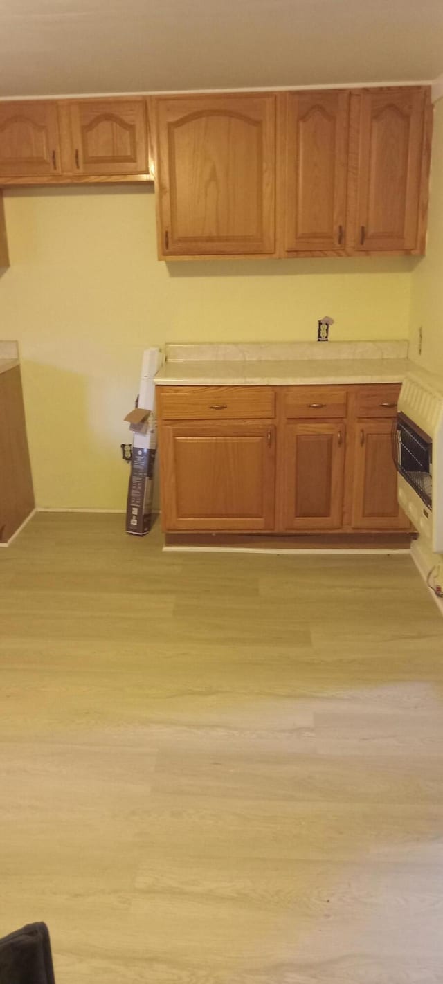 107 E N St, Carlisle, KY 40311 - kitchen featuring heating unit, light countertops, light wood-style floors, and brown cabinetry