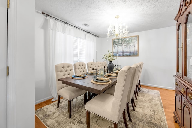 356 Weslyn Way, Nicholasville, KY 40356 - dining area featuring a chandelier, a textured ceiling, light wood finished floors, and baseboards