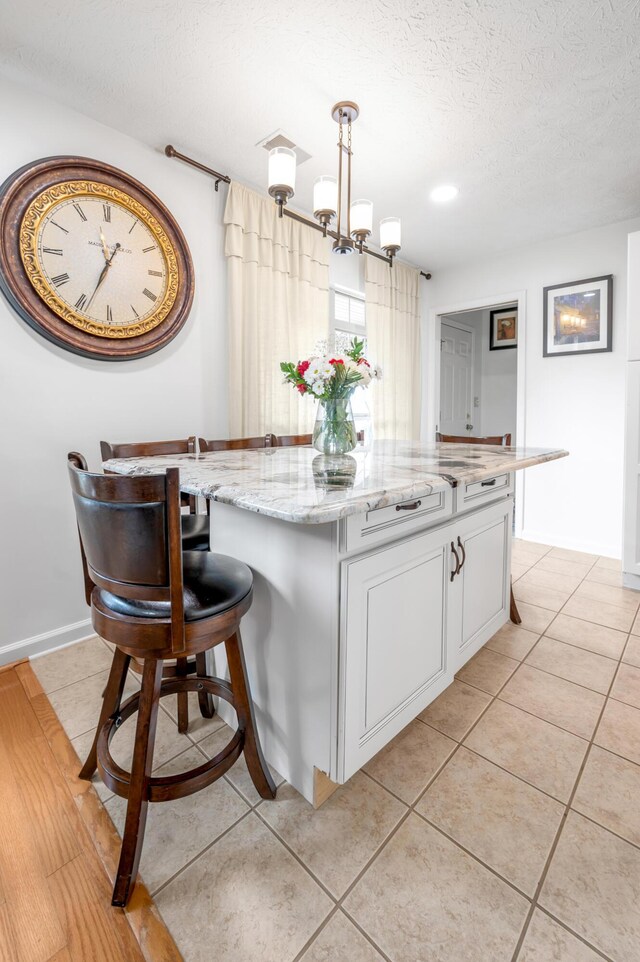 356 Weslyn Way, Nicholasville, KY 40356 - kitchen with a textured ceiling, light tile patterned floors, a chandelier, white cabinets, and light stone countertops