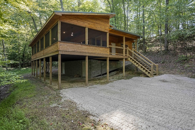 3786 Shoemaker Rdg, Beattyville, KY 41311 - view of front facade with a sunroom, stairway, a carport, a view of trees, and driveway