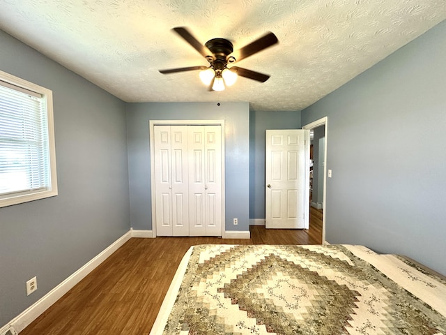 498 Winding Blade Rd, East Bernstadt, KY 40729 - bedroom featuring dark wood finished floors, a closet, baseboards, ceiling fan, and a textured ceiling