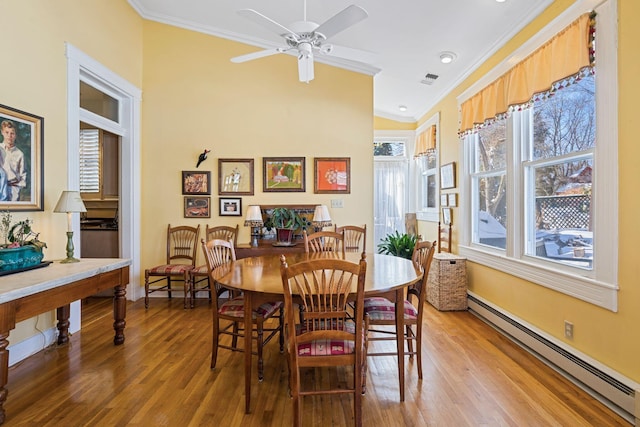 1483 Cypress St, Paris, KY 40361 - dining space with a baseboard heating unit, crown molding, light wood-style floors, ceiling fan, and baseboards